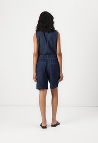 Denim šokiniai su rankovių neturintu dizainu, tamsiai mėlynos spalvos, elastinga juosmens juosta ir dviem užpakalinėmis kišenėmis; kasdieniai iki kelių šortai.