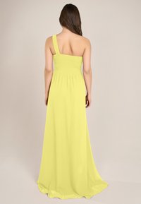 Limettengrünes, einseitig tragbares Maxikleid mit gerüschtem Oberteil, fließendem Rock und leichtem Stoff. Glatte Textur und lange Silhouette.