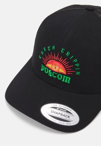 Melnā snapback cepure ar krāsainu izšuvumu, kurā attēlots saule un teksts "EARTH TRIPPIN VOLCOM", teksturēts audums un regulējams aizmugurējais siksniņa.