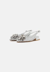 Scarpe slingback intrecciate argento con punta affusolata, dotate di un'imbottitura floreale e tacco basso a blocco. Parte superiore testurizzata con accenti piatti.