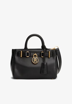 Borsa a mano in pelle nera testurizzata con manico arrotondato, dettagli in oro, ciondolo con logo e tracolla removibile su sfondo bianco.