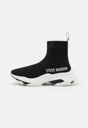 Baskets style chaussette noires avec semelle blanche épaisse et inscription "Steve Madden" sur le côté, avec une languette au talon.