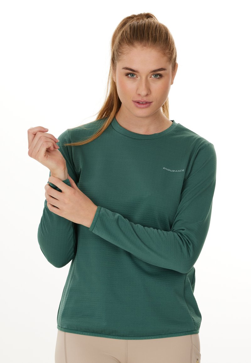 Langærmede, groene sportshirt gemaakt van lichtgewicht stof, met een gladde textuur en subtiele logo-details op de borst.