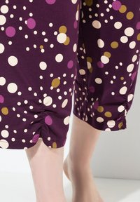 Fioletowe spodnie capri z wielokolorowymi kropkami w białym, różowym i oliwkowym kolorze; marszczone wykończenie u dołu. Miękki, elastyczny materiał bawełniany.