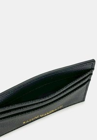 Porte-cartes en cuir noir avec finition texturée, comportant plusieurs emplacements pour cartes et un logo embossé en or sur le devant.