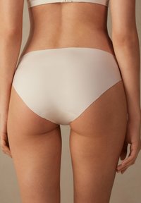 Lichtbeige, gladde stofonderbroek met een middenhoogte snit. Kenmerkt zich door schone randen en geen zichtbare naden, wat een minimalistisch ontwerp biedt.