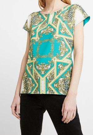 T-shirt à manches courtes en teal avec un motif orné doré et noir, doté d'un col rond et d'une coupe décontractée. Fabriqué en tissu léger.