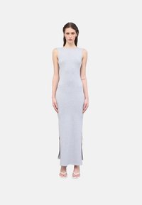 Vestido maxi gris hecho de tela suave, con un diseño ajustado, corte sin mangas y aberturas laterales para facilitar el movimiento. Simple y moderno.