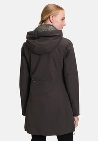 Veste extérieure marron foncé avec capuche, dotée d'une poche arrière zippée et d'une doublure intérieure grise contrastante. Tissu lisse et texturé.