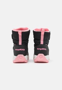 Bottes d'hiver KangaROOS noires et roses avec des languettes de tirage roses et un intérieur doux rose, vues de l'arrière sur un fond blanc.