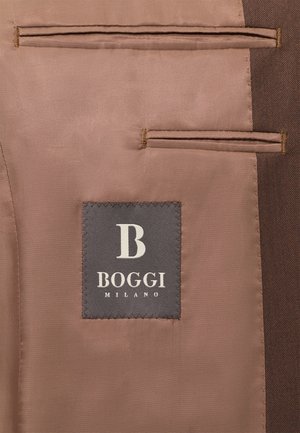 Rjav material s kravato, opremljen z dvema žepoma, z naročito sivo oznako z napisom "BOGGI MILANO" in stiliziranim logotipom "B". Gladka tekstura.