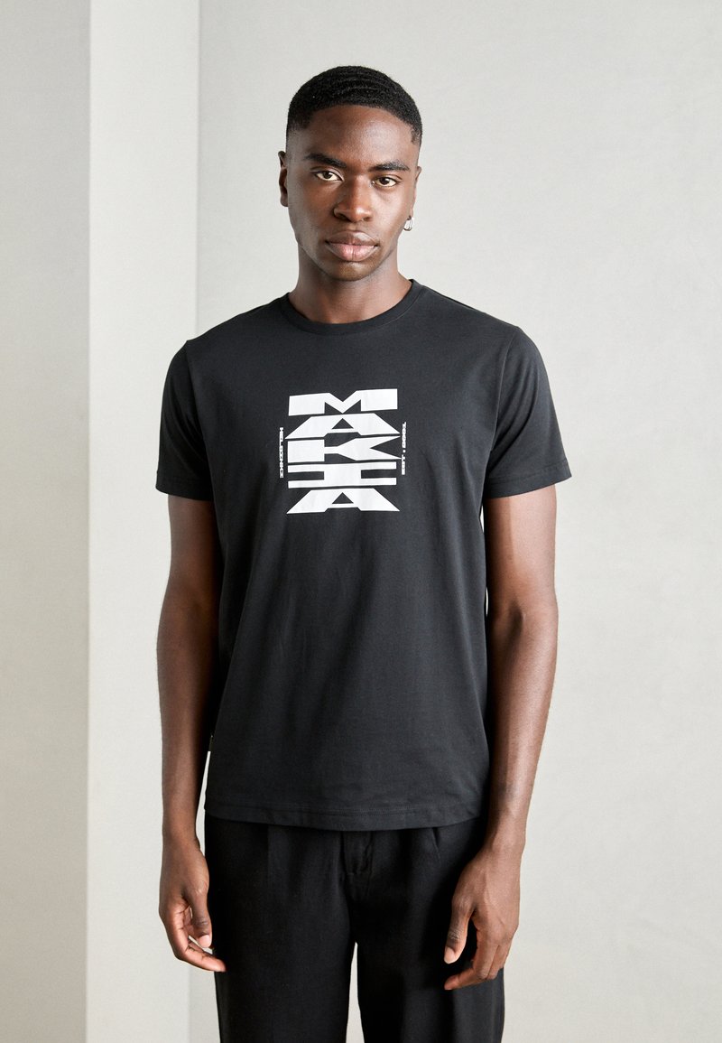 Black short-sleeve T-shirt made of cotton, featuring a bold white graphic print with angular text at the center, smooth texture.