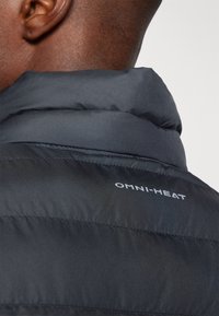 Sort puffjakke med høj krave, påsyede horisontale sektioner og "OMNI-HEAT"-logo på ryggen, der fremhæver den glatte tekstur.