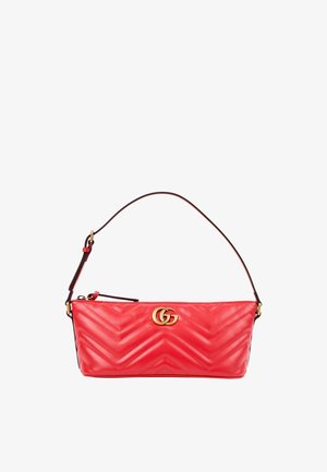 Sac à main en cuir matelassé rouge avec logo double G doré et bandoulière simple sur fond blanc.
