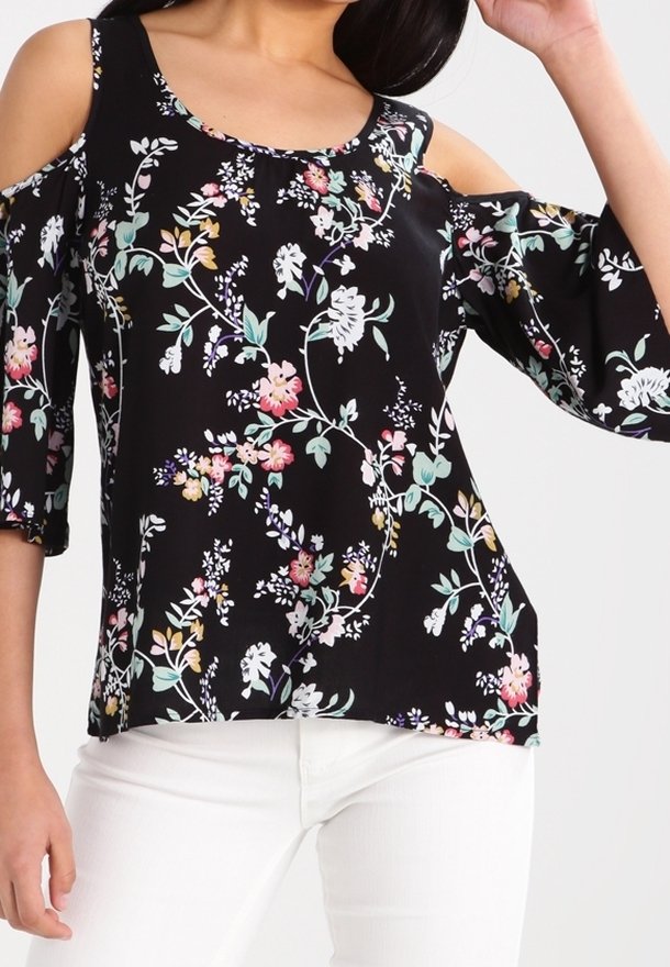 Blusa nera floreale con design cold-shoulder. Presenta vivaci motivi floreali in rosa, bianco e verde su un tessuto setoso. Maniche a tre quarti.