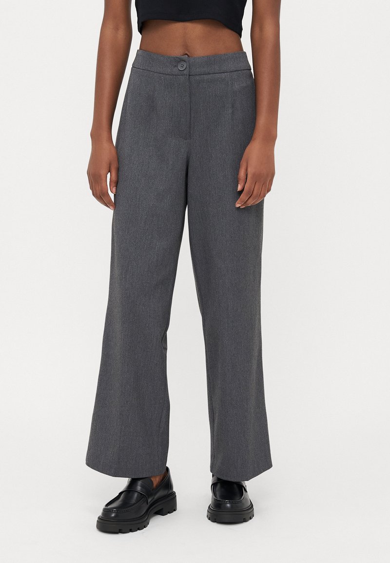 Grå brede bukser med en subtil tekstur, der har knaplukning og plissé-detalje. Stylende med sorte loafers.
