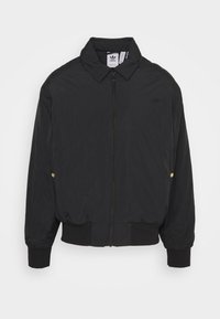 Černá bomber bunda s límečkem, elastickými manžetami a pasem. Má přední zip a decentní logo na hrudi.