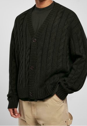 Dunkelgrüner Strickcardigan mit V-Ausschnitt, fünf Knöpfen sowie gerippten Bündchen und Saum. Hergestellt aus einem dicken, strukturierten Stoff.