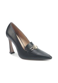 Black leather high-heeled pump with pointed toe, featuring a gold-toned circular accent and a tapered block heel. Smooth texture.