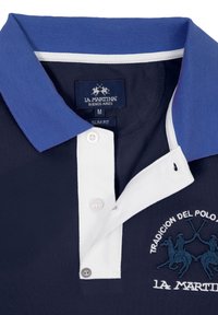 Námořnické polo tričko s tmavě modrým límcem, bílou légou a vyšitým logem se dvěma hráči polo. Slim fit s texturovanou látkou.