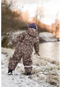 Combinezon de zăpadă mov cu model floral, cu glugă, talie elastică și accente albe. Caracterizat printr-un design pufos și mănuși asortate.