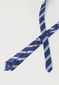Γραβάτα σε ναυτικό μπλε με ανοιχτό μπλε και λευκές διαγώνιες ρίγες, τοποθετημένη επίπεδα σε λευκή επιφάνεια.