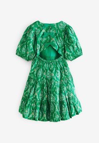 Vestito verde floreale con maniche a palloncino, schiena scoperta e gonna a strati. Realizzato in tessuto leggero, presenta intricati motivi floreali e fiocchi.