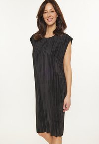 Rochie neagră plisată cu o croială lejeră, mâneci tip capac și tiv până la genunchi. Materialul prezintă dungi verticale fine, creând un aspect texturat.