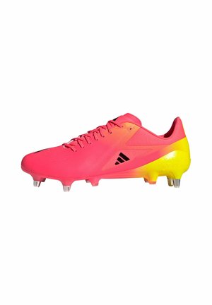 Jaskrawo różowe i żółte korki piłkarskie Adidas z metalowymi kołkami i czarnym logo po bokach, widziane z zewnętrznej strony.