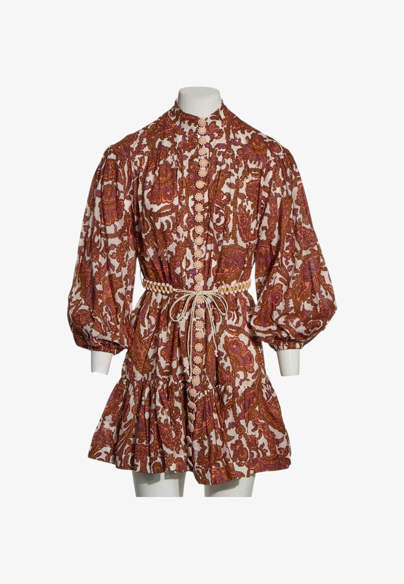 Robe courte à manches bouffantes, boutons floraux, motif paisley marron et violet, et ceinture nouée à la taille sur un mannequin blanc.