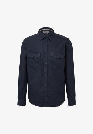 Chemise à manches longues en coton, de couleur marine, avec un col boutonné, deux poches poitrine et un ourlet droit avec de légentes fentes sur les côtés.