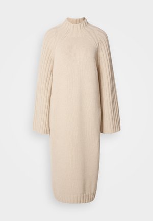 Jasno beżowa dzianinowa sukienka z wysokim kołnierzem, ribbowanymi rękawami i prostą sylwetką, wykonana z teksturowanej tkaniny dla dodatkowego ciepła.