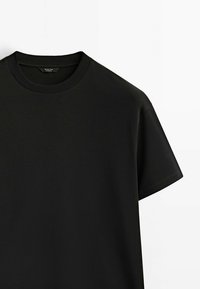 T-shirt noir manches courtes à col rond en tissu lisse, montré de face sur fond blanc.