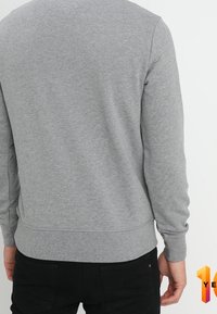 Sudadera gris de mezcla de algodón, con mangas largas, dobladillo acanalado y un diseño simple y liso sin patrones.