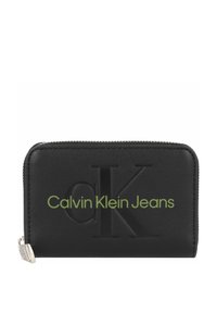 Portafoglio in pelle nera con logo impresso. Chiusura a zip, forma rettangolare e testo verde "Calvin Klein Jeans" sul davanti.