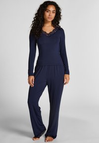 Ensemble de pyjama en bleu marine à manches longues avec une bordure en dentelle au niveau du col et des ourlets des pantalons, offrant une coupe décontractée et une texture douce.