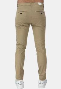 Chino beige con una vestibilità slim, chiusura con zip e bottone, due tasche posteriori con bottone e una texture liscia in misto cotone.