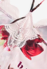 Blumiges Satin-Camisole mit einem zarten Spitzenbesatz am Ausschnitt, verstellbaren Trägern und einem weichen, pinkfarbenen und bunten Muster.