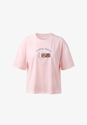Jasnoróżowy T-shirt z napisem „"Cute Bear"” nad trzema haftowanymi, kreskówkowymi pyszczkami misiów na klatce piersiowej. Brak widocznej osoby, która go nosi.
