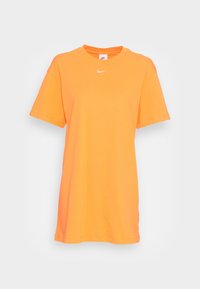 Lys orange kortärmad Nike t-shirt med liten vit Nike swoosh-logga centrerad under kragen, enkel framsida, rund hals.