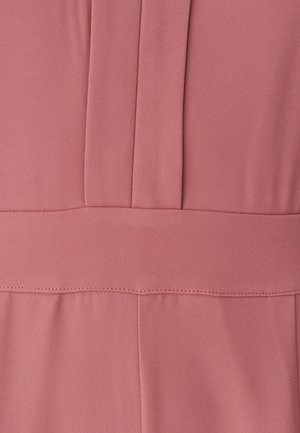 Růžová látka s hladkým povrchem, obsahující řasení a horizontální šev v pase. Jednoduchý design bez viditelných ozdob.