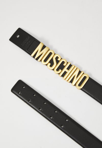 Must musträhv värvitud vöö, millel on suur kuldne "MOSCHINO" logo pandla külge. Vööl on mitu auku, et saaks reguleerida suurust.