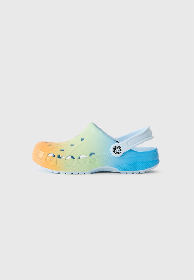 Zuecos Crocs coloridos con un degradado que va del naranja al verde claro y azul. Fabricados con un material ligero, cuentan con agujeros de ventilación y una correa trasera.