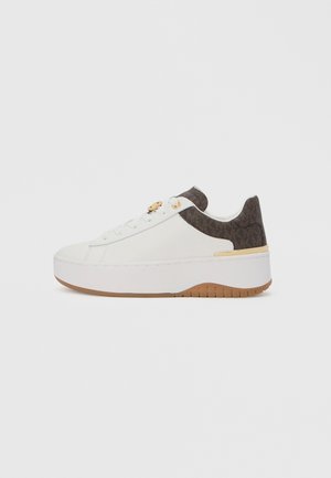 White sneaker with a textured brown accent at the heel, featuring a gold-tone eyelet, round toe, and a thick white sole with a gum tread.
