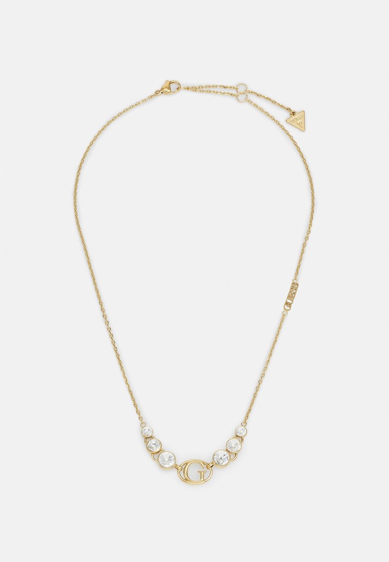 Collier fin en chaîne d’or avec un pendentif central "G" et six pierres précieuses rondes et claires, trois de chaque côté du pendentif.