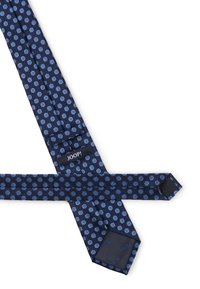 Cravate en soie bleu marine avec un motif floral à pois bleu clair et étiquette "JOOP!", posée à plat sur un fond blanc.