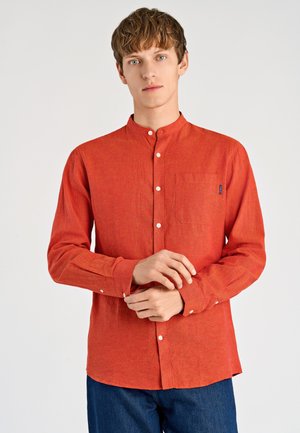 Camicia rossa a maniche lunghe con collo alla coreana, davanti con bottoni e taschino sul petto. Realizzata in tessuto strutturato, presenta bottoni bianchi.