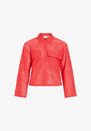 Chemise rouge à manches longues en dentelle avec des motifs floraux et géométriques, fermeture à boutons sur le devant, col et deux poches à rabat sur la poitrine.