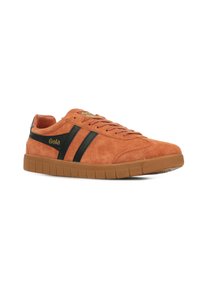 Sneaker in suede arancione con strisce nere, punta tonda e suola in gomma texturizzata. Dettaglio del logo dorato sul lato.