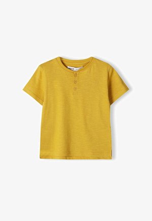 Gelbes Kurzarm-T-Shirt aus weicher Baumwolle, mit einer Knopfleiste mit drei Knöpfen und einem kleinen, auf der Brust gestickten Logo.